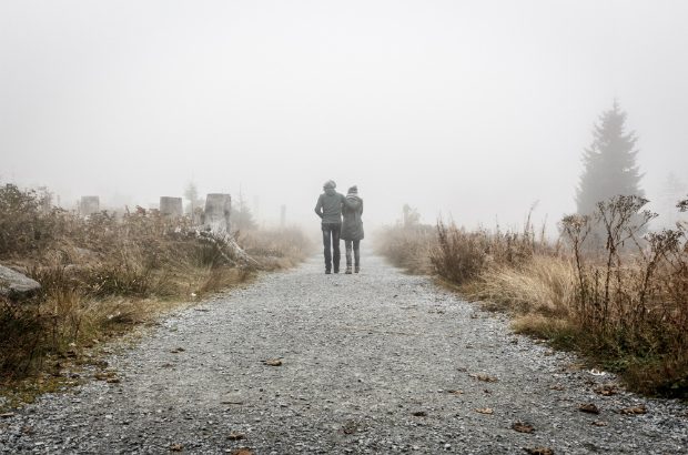 Two people walking on a road through the mist (Sebastian Pichler/CC0)